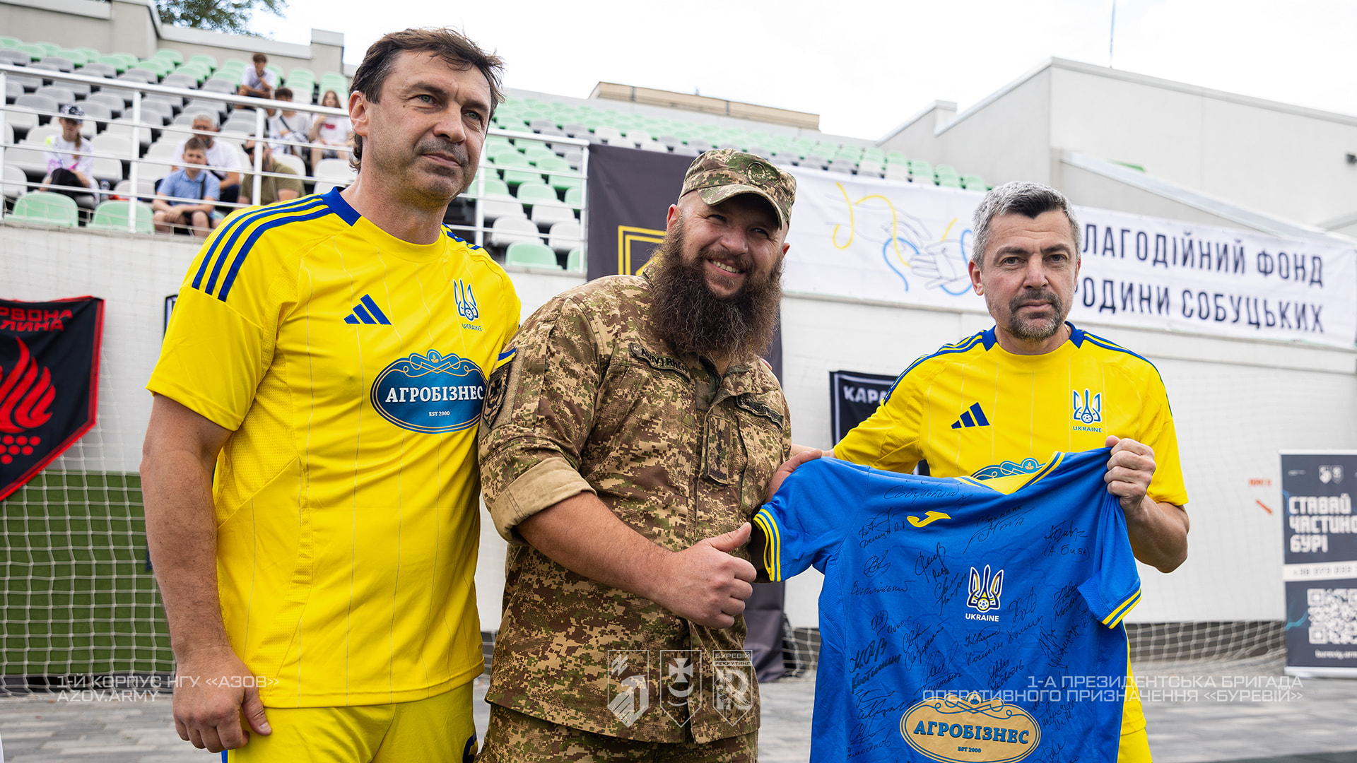 Військовому вручають пам'ятну футболку з підписами учасників благодійного футбольного матчу