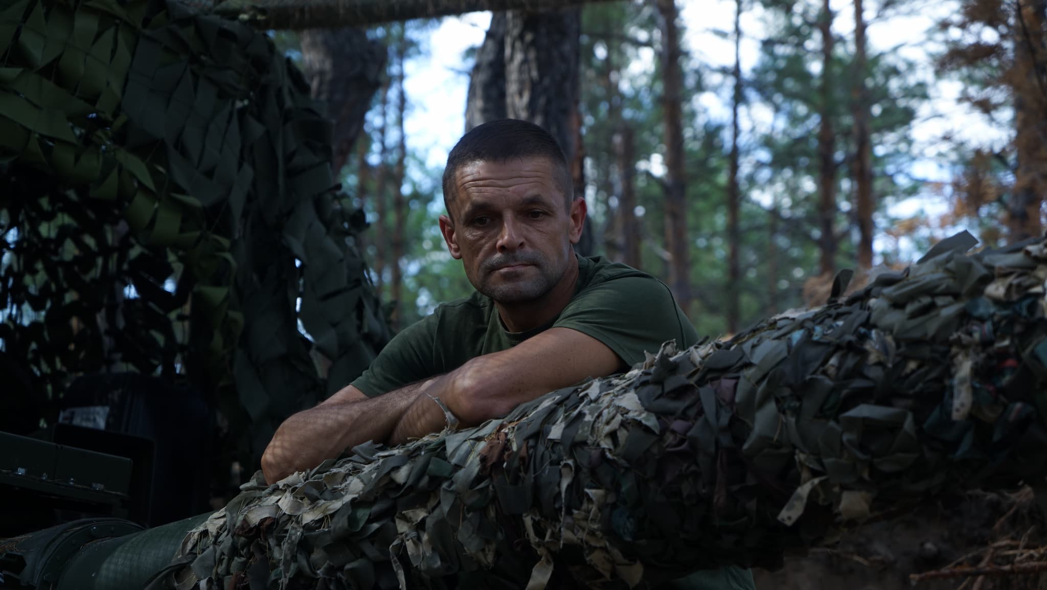 Танкіст спирається на замасковану гармату